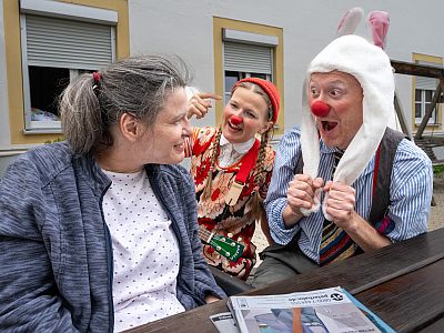 Zwei KlinikClowns beim Besuch eines Menschen mit Behinderung