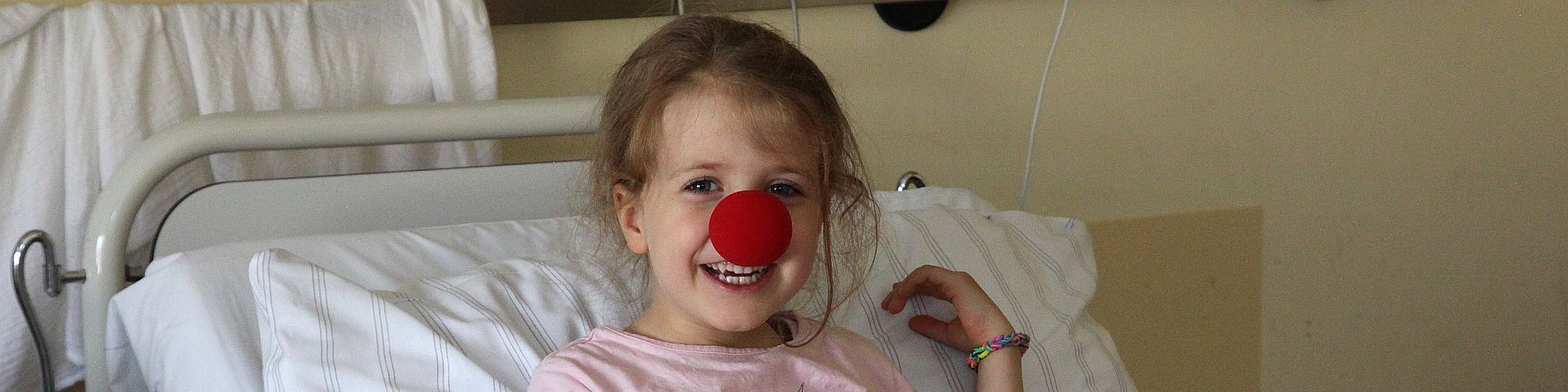 Kind im Krankenhaus mit Clownsnase